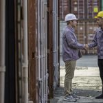 two construction workers shaking hands with each other