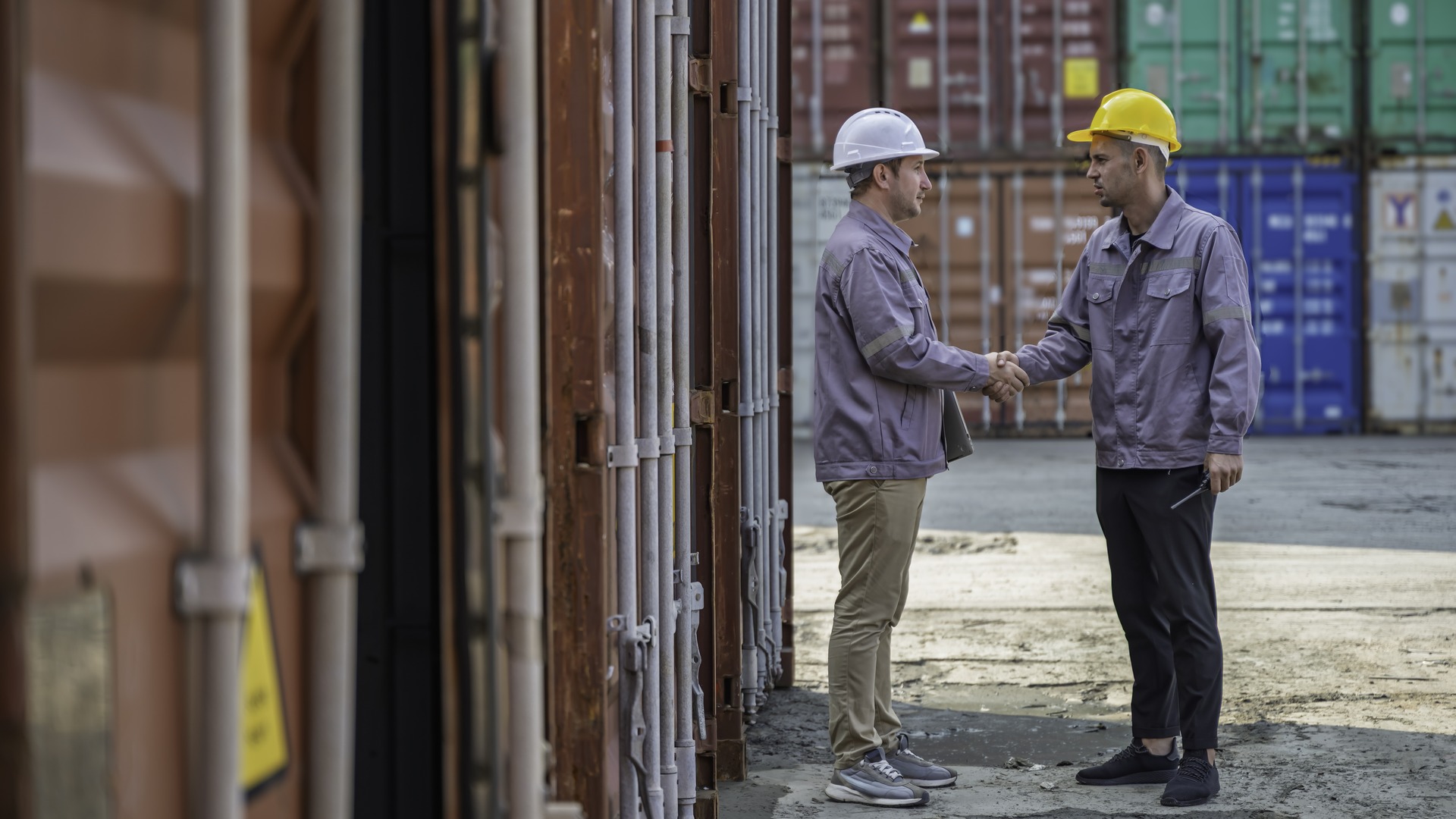 two construction workers shaking hands with each other