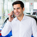 Man talking on a mobile phone with some cars at the background