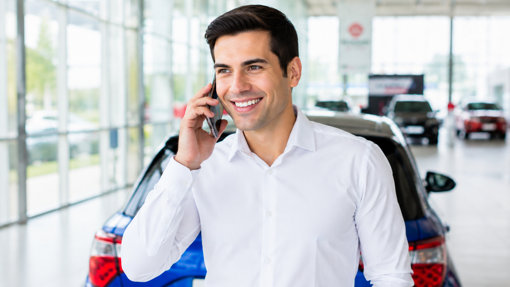 Man talking on a mobile phone with some cars at the background