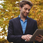 man with a tablet with trees in the background