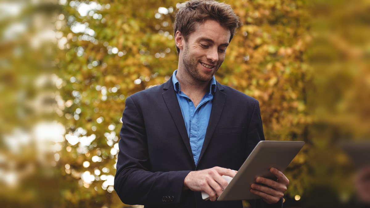 man with a tablet with trees in the background